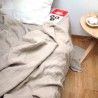 Drap plat en lin lavé couleur beige avec une table et sur parquet