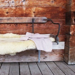 Torchon en pur lin beige avec des rayures rouges sur un banc